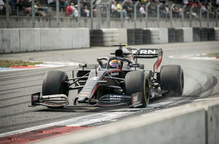 Monoplace de Formule 1 en pleine courbe sur un circuit de Grand Prix, illustrant la technique de gestion de vitesse lift and coast